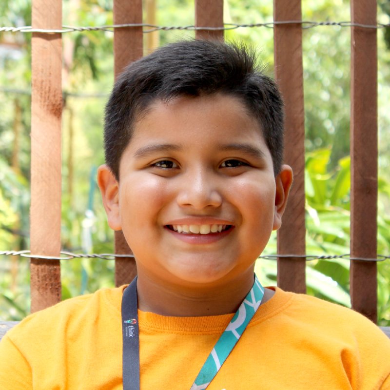 boy smiling with wood fence background